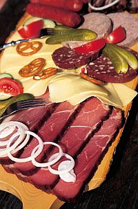 wooden board with ham, cheese and sausage