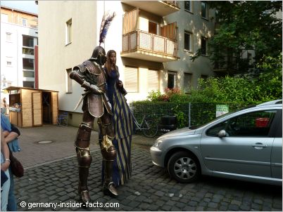 walking on stilts in colourful costumes