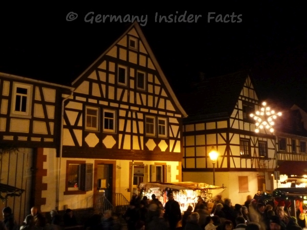 Photo of beautiful half-timber houses, Christmas lights and small food stalls at a Christmas market in Germany Photo of beautiful half-timber houses, Christmas lights and small food stalls at a Christmas market in Germany